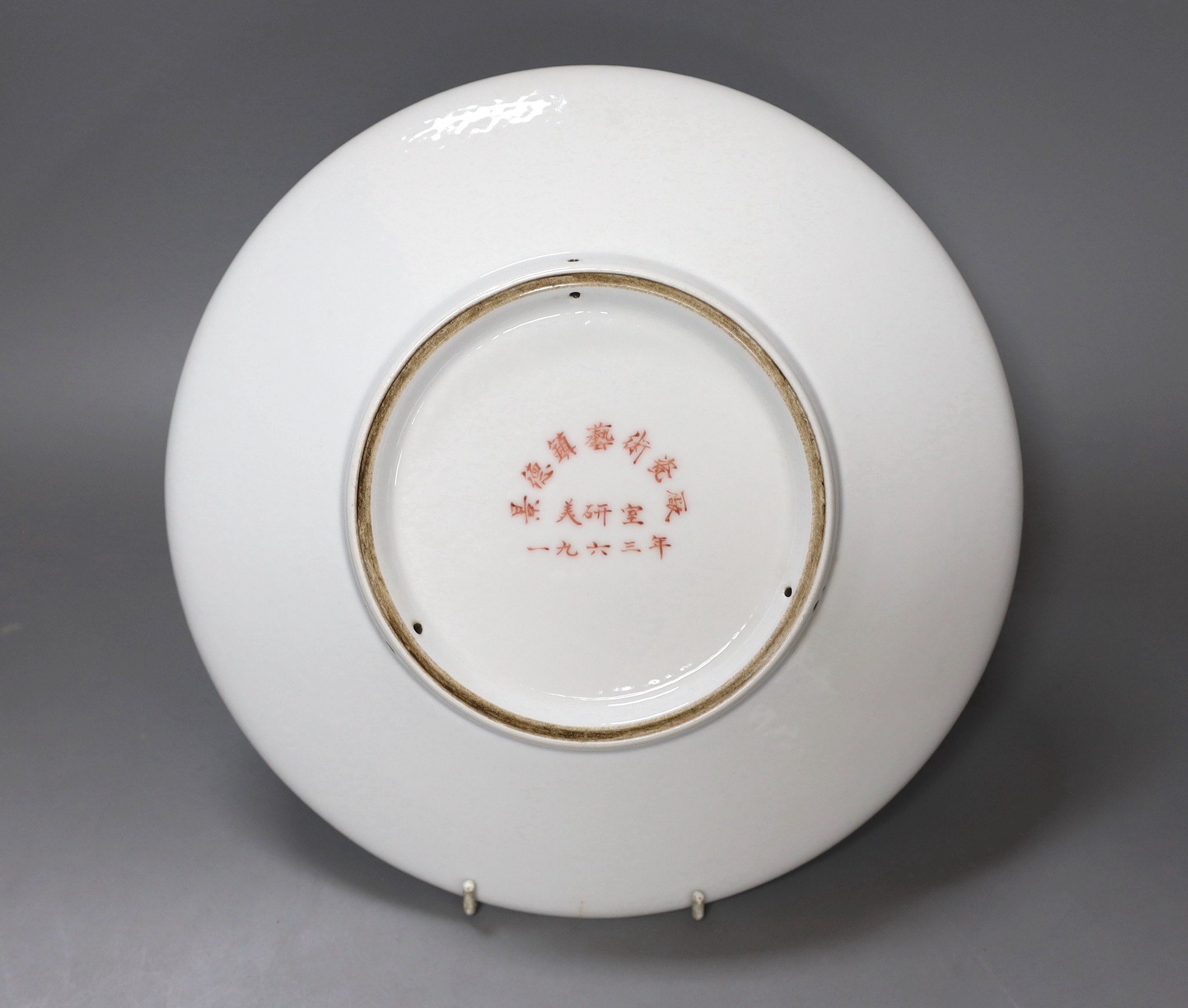 A Chinese famille rose plate of a walking figure with inscription, 28cm diameter